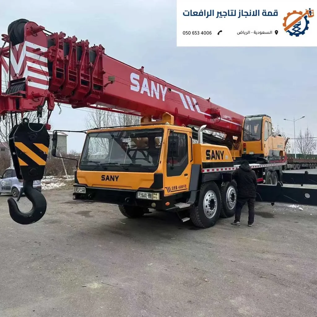 كرين تلسكوبي ضخم حديث بلون أصفر يقوم برفع هيكل معدني ثقيل في موقع إنشائي بمنطقة الرياض.